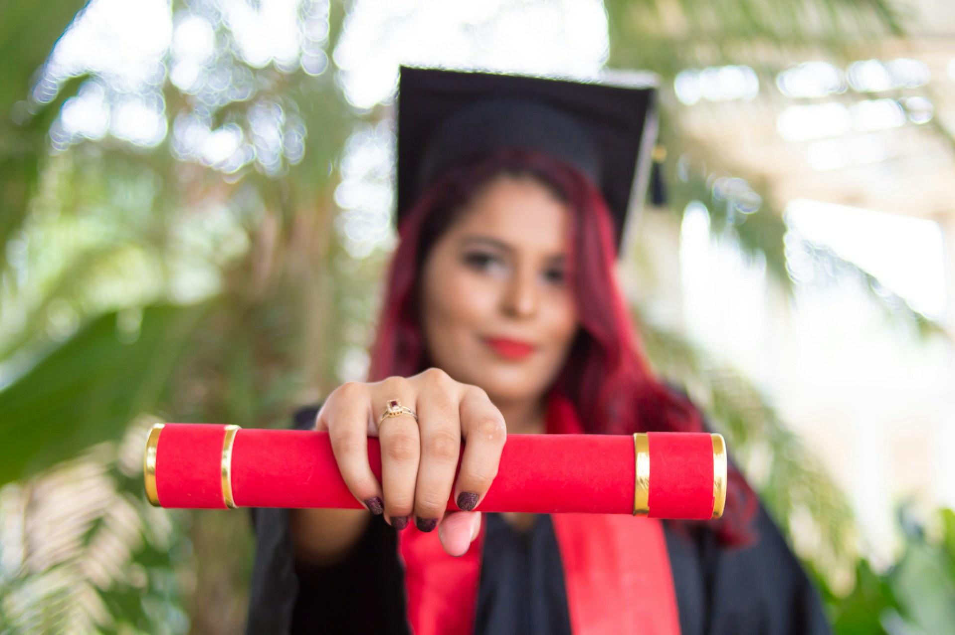 Una mujer sosteniendo un diploma de graduación.